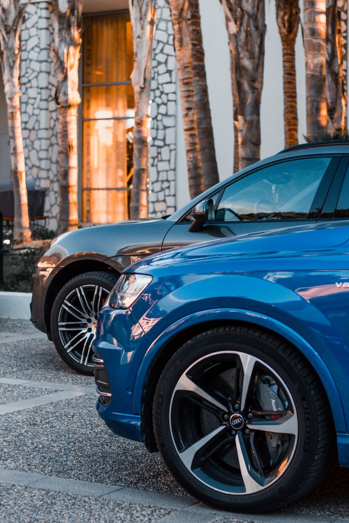 Close-up of a blue and black car parked outdoors, showcasing luxury automotive design.
